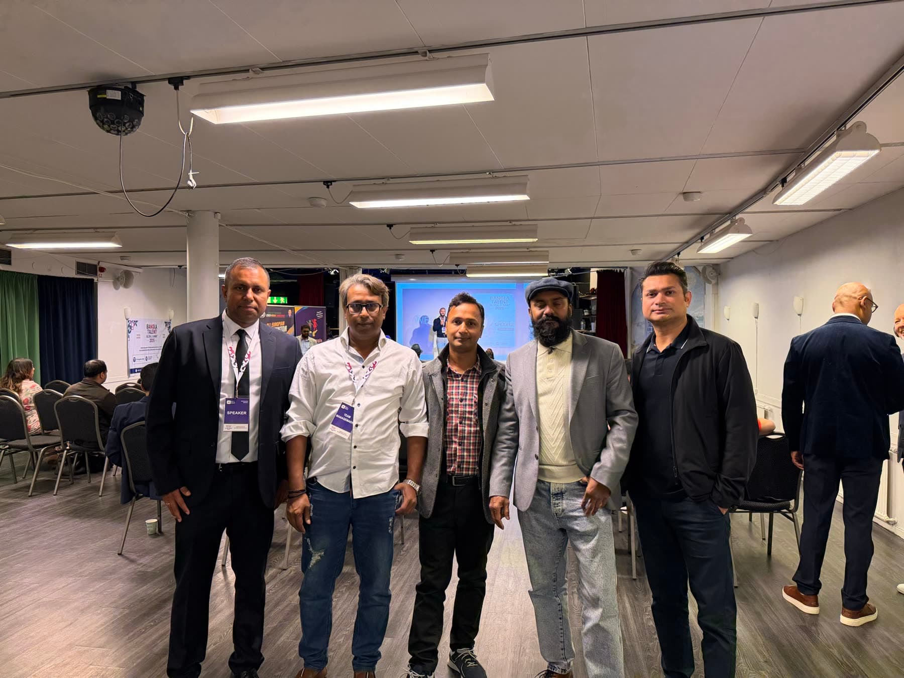 A group of guests stands together in the summit hall
