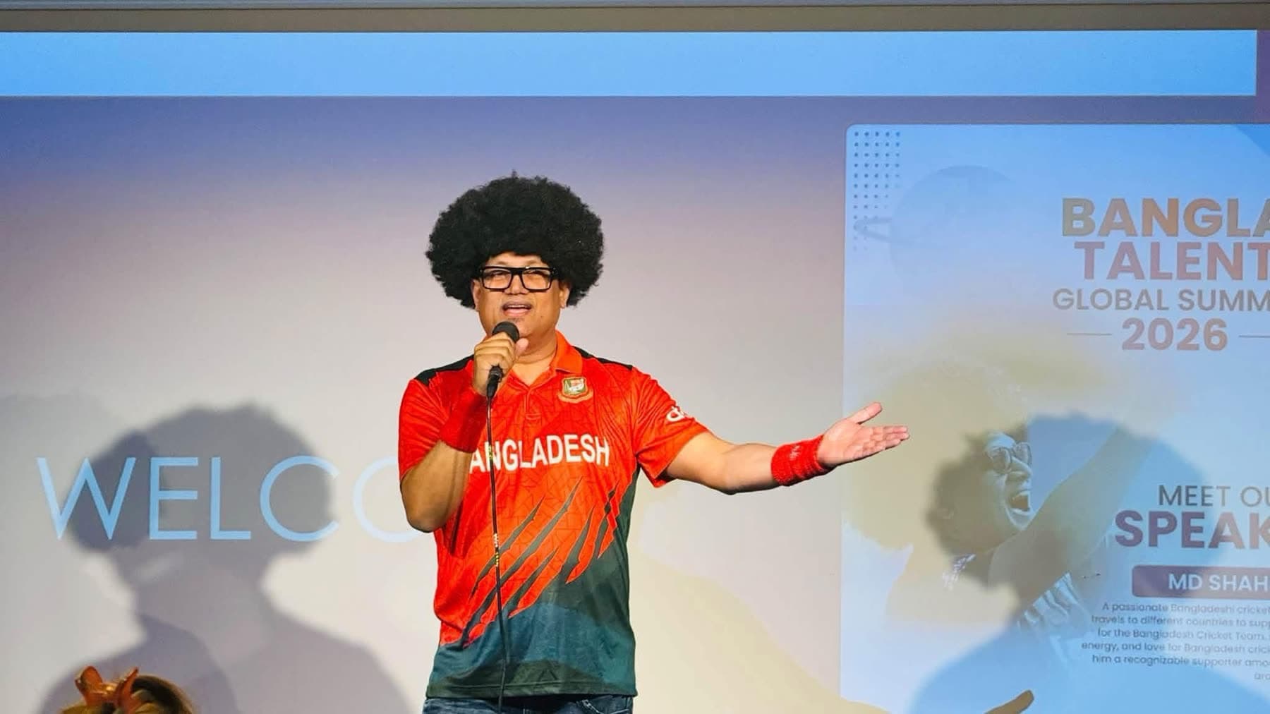 A performer in a Bangladesh football jersey and a curly wig entertains the audience